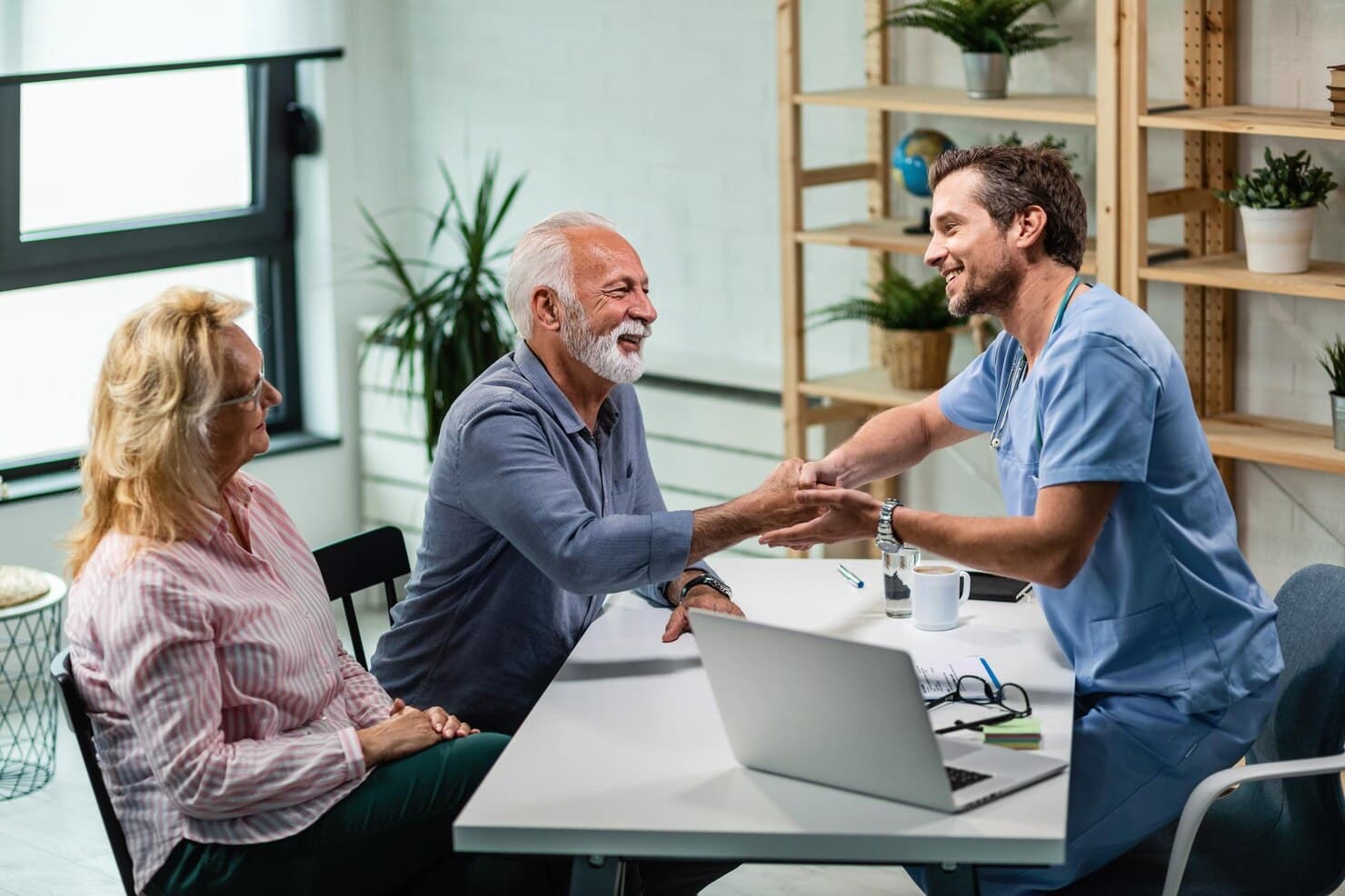 Care coordinator shaking hands with a happy patient and family