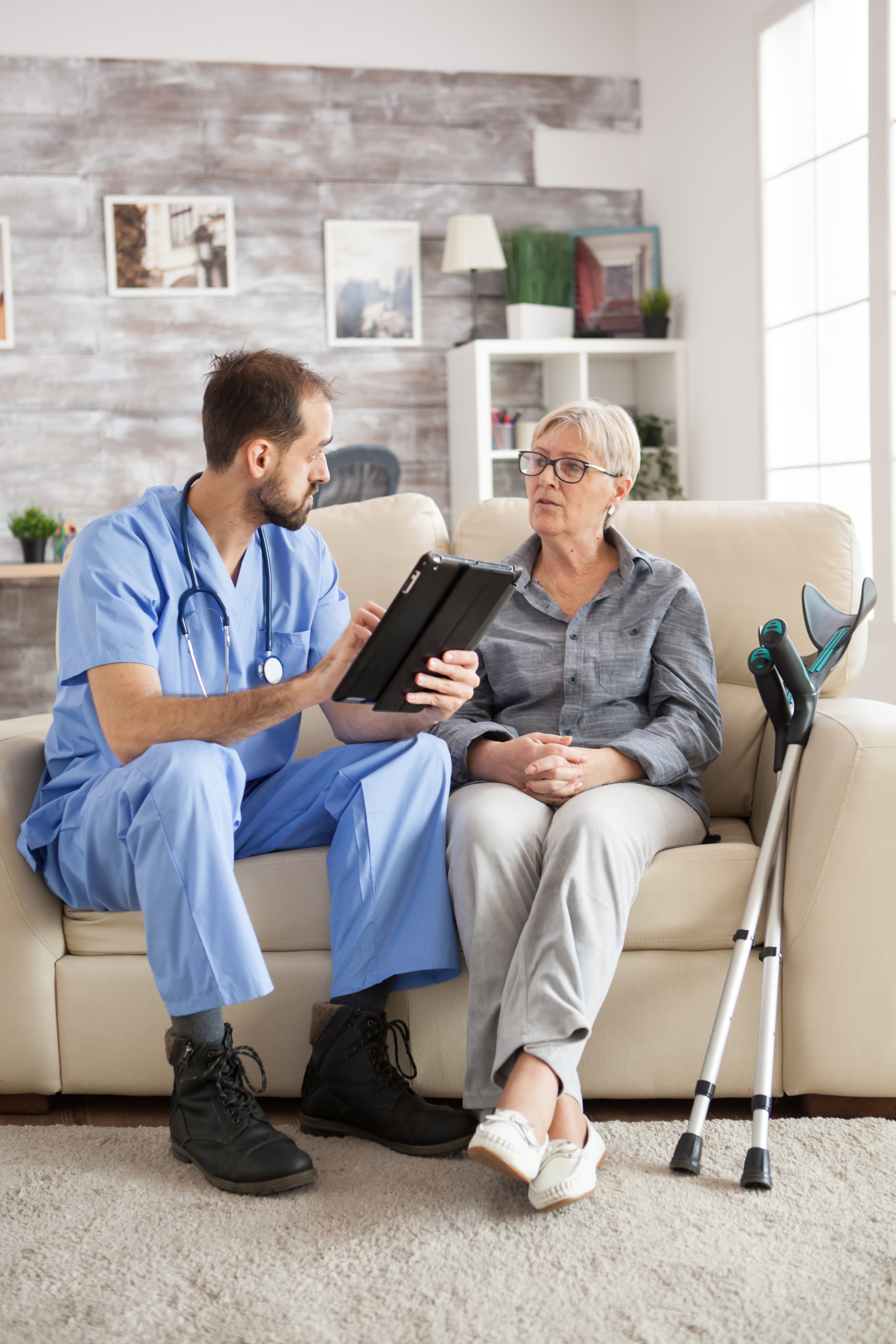 Nurse reviewing a home care plan with a patient on a tablet